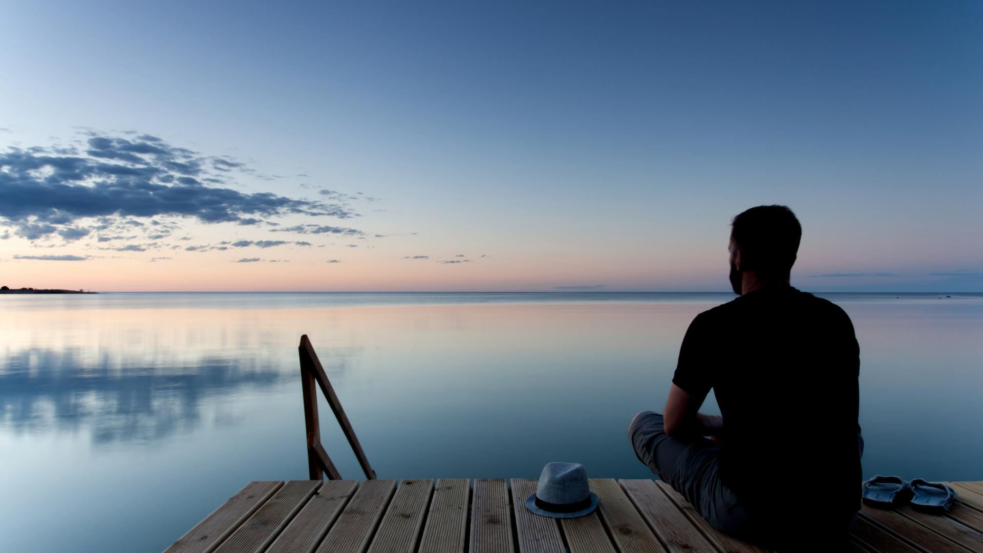Man blickar ut över havet från en brygga.